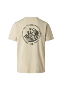 T-shirt en coton beige avec un grand motif vert représentant une montagne et un texte circulaire indiquant "Fournir du matériel pour l'explorateur moderne."