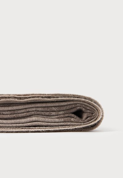 Couverture épaisse en laine brune pliée sur fond blanc, montrant la texture et les bords superposés.