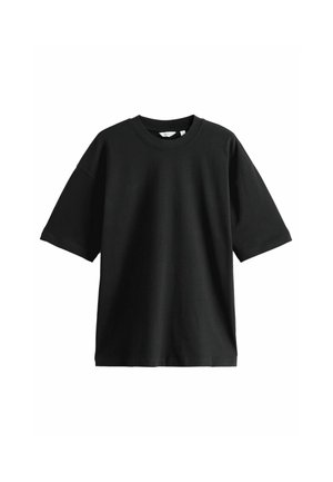 Camiseta negra de manga corta hecha de algodón, con cuello redondo y un corte holgado, con una textura suave y un diseño minimalista.