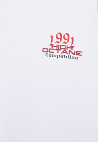 Tissu blanc avec texte rouge et noir indiquant « 1991 High Octane Competition » centré sur la surface.