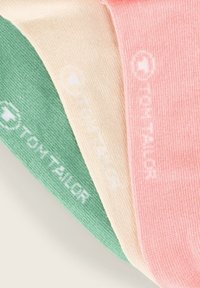 Tres pares de calcetines dispuestos. Colores: verde, durazno y crema. Cada uno presenta un tejido texturizado y la marca "TOM TAILOR" en blanco.