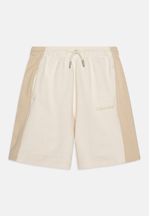 Šortky Calvin Klein vyrobené z bavlneného zmesi, so smotanovým základom a hnedými bočnými panelmi, elastickým pásom a šnúrkou na stiahnutie. Dva bočné vrecká.