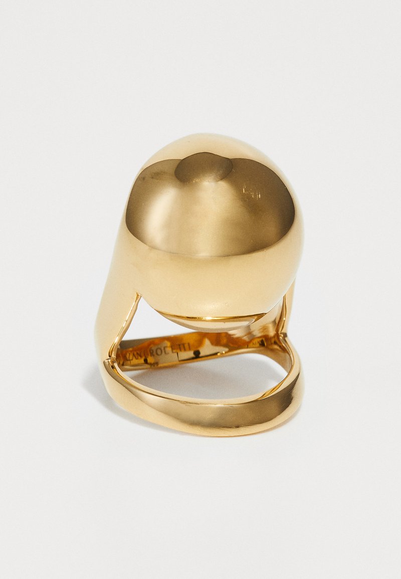 Bague en finition dorée présentant un dessus en dôme lisse et arrondi, un design de bande ouverte, et une finition polie, avec une gravure intérieure.