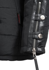 Black puffer jacket sleeve with leather accents, featuring a prominent silver zipper, snap closures, and a tag with "Navajo" branding.