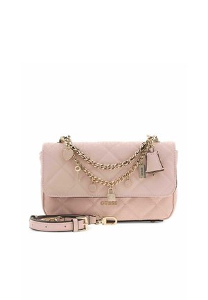 Sac à main matelassé rose clair Guess avec chaîne en or, breloques, détail de serrure et bandoulière amovible sur fond blanc.