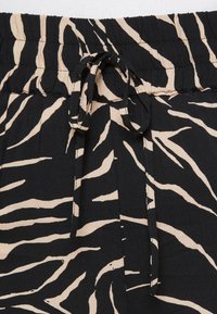 Černý a béžový pás s potiskem zebry a stahovacím šňůrkou. Hladká tkanina s měkkou texturou a elastickým pasem pro pohodlí.