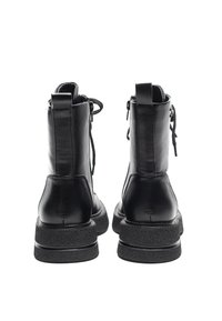 Black leather ankle boots with a structured design, zipper closure, and textured rubber outsole. Features a round toe and back pull tab.
