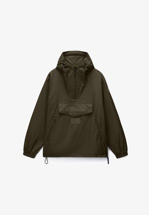 Olivově zelená anoraková bunda s kapucí, předním půlzipem, velkou kapsou na prsou se záklopkou, zipovými bočními kapsami a elastickými manžetami.