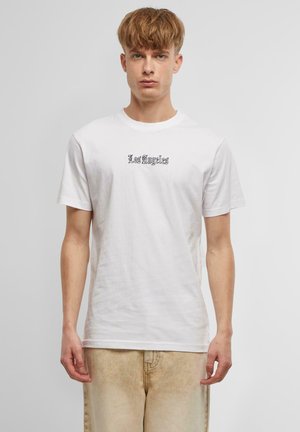 White cotton t-shirt featuring a "Los Angeles" graphic in black script. Short sleeves and a classic crew neck design.