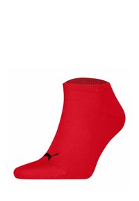 Calcetín rojo hasta el tobillo hecho de tejido texturizado, con puño acanalado y logo negro. Diseñado para ajustarse cómodamente al pie.