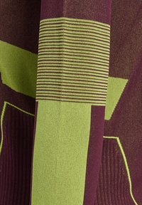 Tekstil med dristige mønstre i lilla og limegrøn; indeholder lodrette og vandrette striber med forskellige teksturer og tykkelser.