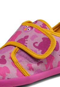Pink fabric shoe with yellow trim, featuring a dinosaur and owl pattern. Design includes adjustable strap and textured rubber sole.