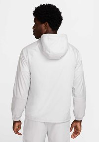 Witte hooded jacket met elastische manchetten en een gladde textuur. Kenmerkt een minimalistisch ontwerp, achteraanzicht en een relaxte pasvorm voor comfort.