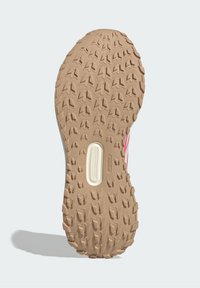 Zool met grip, bestaande uit een beige rubberen basis met een getextureerd patroon van multidirectionele groeven en een wit accent nabij het midden.