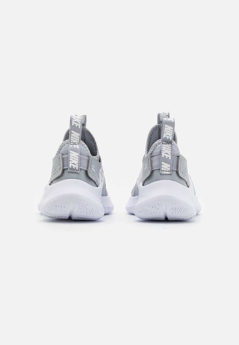 Graue Sportschuhe mit einer strukturierten Oberseite, verstärktem Absatz und weißer Gummisohle. Sie verfügen über eine auffällige graue Zuglasche mit Markenbeschriftung.