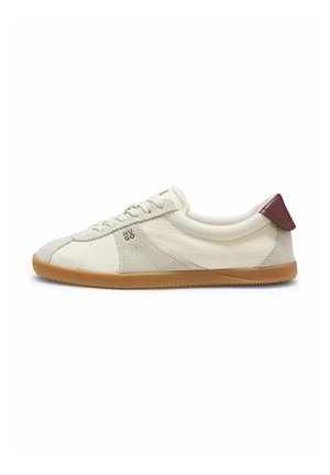 Fladprofil cremefarvet sneaker med gummisål, ruskind detaljer, snørefront, mørkerød hælflig og "HUGO" mærkning på siden.