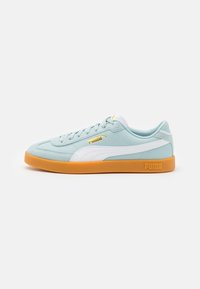 Sneakers azzurro chiaro con dettagli bianchi, suola in gomma, punta arrotondata, logo dorato sul lato e materiale texturizzato, progettati per un uso casual.