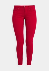 Vaqueros ajustados de color rojo brillante con cierre frontal de botón y cremallera, cinturillas y diseño de cinco bolsillos, exhibidos sobre un fondo blanco.