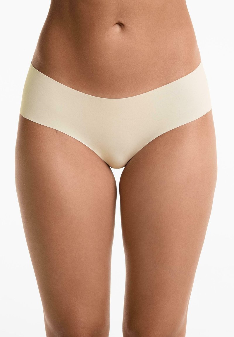 Beige, varratnélküli hipster alsónemű, sima, puha textúrával és alacsony derékpánttal, egyszerű dizájnnal, látható varrás nélkül.