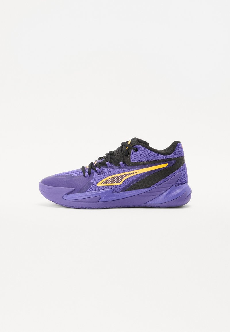 Fialový a černý sportovní sneaker s žlutým akcentovým pruhem, černými tkaničkami a texturovanou podrážkou, zobrazený z boku na bílém pozadí.