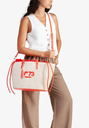 Borsa tote intrecciata beige con dettagli arancioni, dotata di chiusura con coulisse e ricamo con marchio. Include una lunga tracolla regolabile e un dettaglio con nappina.