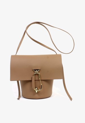 Bolso tipo cubo de cuero marrón con una correa larga y un distintivo cierre grande de oro en la solapa frontal.