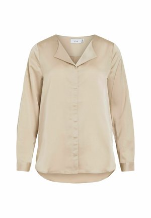 Blusa beige de manga larga con un acabado satinado y elegante. Presenta un cuello puntiagudo y cierre frontal con botones. Con dobladillo redondeado, corte relajado y mangas estructuradas.