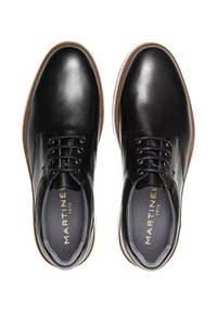 Par de zapatos de vestir de cuero negro con cordones y suelas marrones, vistos desde arriba sobre un fondo blanco.