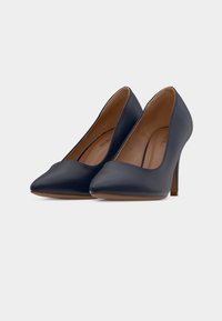 Μπλε ναυτικό γοβάκια με ψηλό τακούνι, μυτερή μύτη, λεία εξωτερική επιφάνεια από δέρμα, λεπτά τακούνια στιλέτο και απαλή καμπύλη στα ανοίγματα.