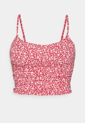 Rdeča cvetna krajšna majica s tankimi naramnicami. Tkanina ima bel cvetni vzorec in guban teksturo ob straneh za prilegajoč videz.