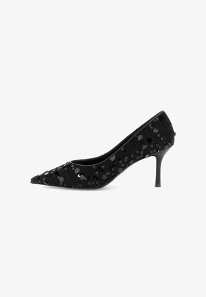 Scarpe con tacco stiletto a punta nera per donna, rivestite di paillettes, mostrate in profilo laterale su sfondo bianco.