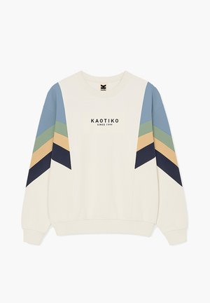 Beige Sweatshirt mit Chevron-Streifen in Blau, Grün, Beige und Marineblau an den Ärmeln sowie der Aufschrift "KAOTIKO SINCE 1999" auf der Vorderseite.