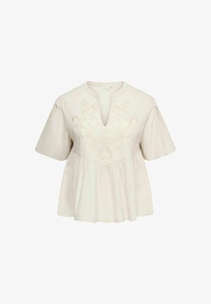 Blouse blanche à manches courtes avec col en V, broderie florale sur la poitrine, coupe ample et tissu froncé sous la poitrine.