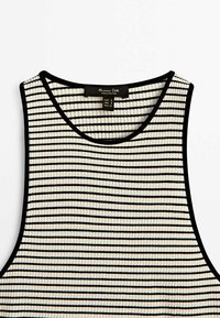 Stribet tanktop med sorte og hvide skiftende striber, ribbet tekstur og en rund halsudskæring med sort kant.