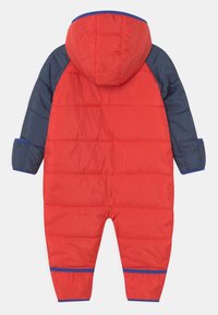 Czerwono-granatowy ocieplany kombinezon z kapturem, z poziomym przeszyciem, elastycznymi mankietami oraz niebieskimi akcentami na rękawach i nogawkach.