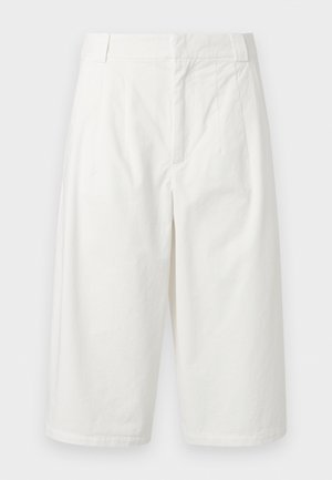 Λευκό φαρδύ παντελόνι cropped με θηλιές για ζώνη, φερμουάρ μπροστά και πλαϊνές τσέπες σε απλό φόντο.