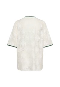 Bela čipkasta majica z cvetnim vzorcem, kratkimi rokavi in zelenim obrobo okoli vratu. Lahka, teksturirana tkanina s sproščenim dizajnom.