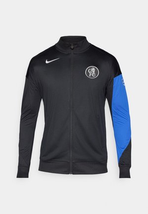 Black zippered jacket with black body and blue sleeve. Features Nike logo and FC emblem, made from lightweight, smooth fabric.