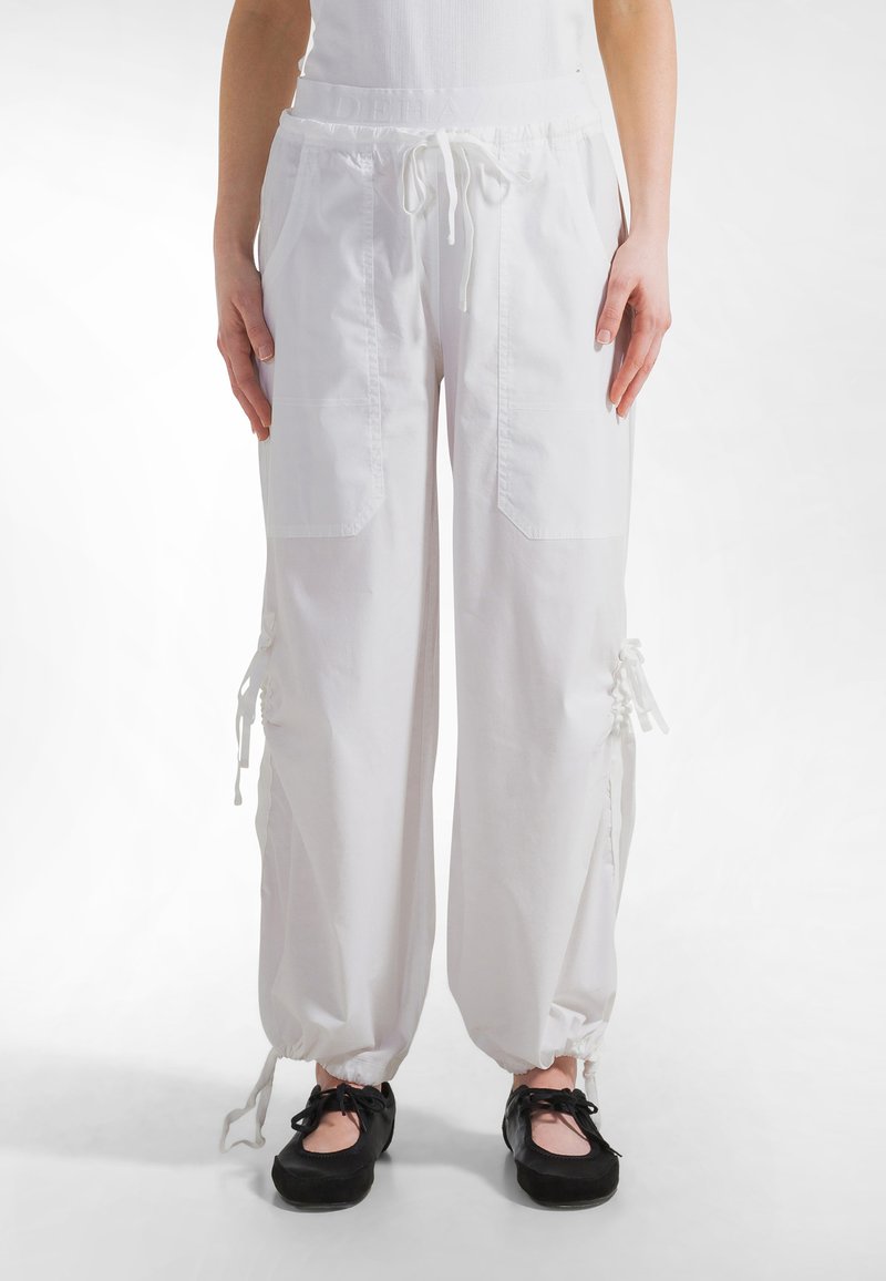 Hvide bomuldsjoggerbukser med elastik i taljen, snøre og sidelommer; med snøre detaljer ved kanten for justerbar pasform.