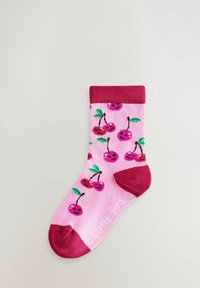 Roosa sokk punase varba, kand ja soonikuga, kaunistatud naeratavate kirsi paaride ja roheliste lehtedega.