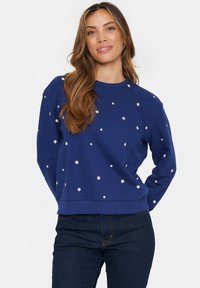 Felpa blu realizzata in tessuto morbido, con motivi di stelle bianche sparsi sul davanti, col collo a giro e polsini a coste.