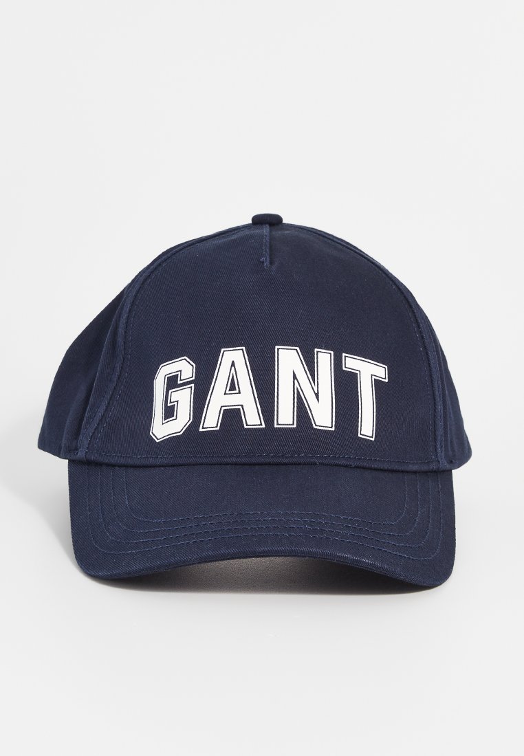 Mörkblå basebollkeps med böjd skärm och vit "GANT" text centrerad på frampanelen mot en enfärgad bakgrund.