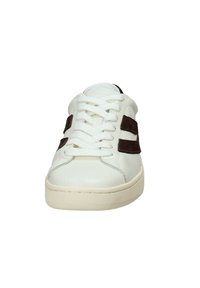 Weiße Sneaker mit beiger Sohle und schwarzen Wildleder-Doppellinien, Frontalansicht mit Schnürsenkeln und abgerundetem Zehenbereich.