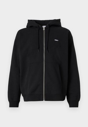 Schwarze Zip-Hoodie aus weichem Material mit einer vorderen Kängurutasche und einem kleinen weißen "OBEY"-Logo auf der Brust. Verstellbare Kapuze mit Kordelzug.