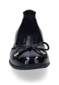 Černé lakované ploché boty s kulatou špičkou, ozdobná mašle se zlatými akcenty na přední straně a flexibilní podrážka.