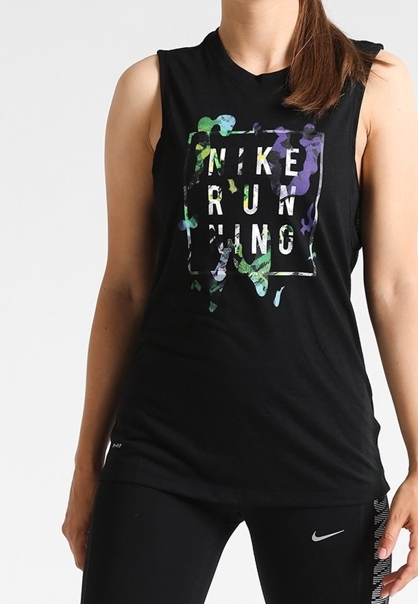 Femme portant un débardeur de course Nike noir avec un texte floral coloré et des leggings noirs Nike avec logo visible.