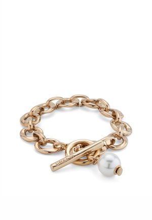 Pulsera de cadena de oro con eslabones grandes, un cierre de palanca grabado con "UNOde50" y un único colgante de perla blanca.