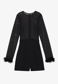 Musta haalari pitkillä hihoilla; läpinäkyvä, timanttikuvioinen yläosa ja kestävät shortsit. Ominaisuudet mustasta keinokarvasta valmistetut hihansuut ja pyöreä kaulus.