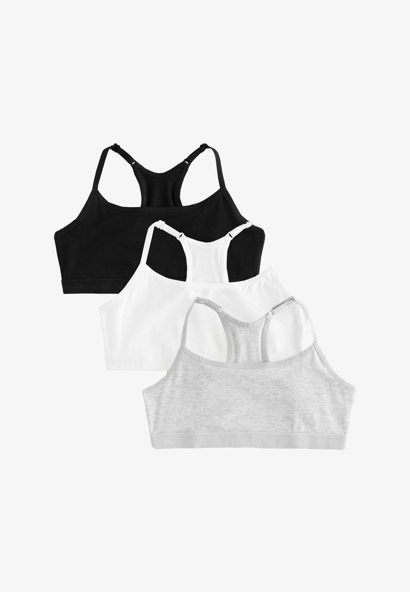 Trois soutiens-gorge de sport dos nageur en noir, blanc et gris clair, disposés en chevauchement sur un fond blanc.