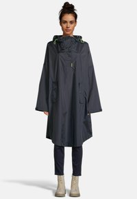 Poncho étanche gris foncé avec capuche, poches latérales, cordon de serrage réglable et coupe ample. Texture lisse, adapté aux intempéries.